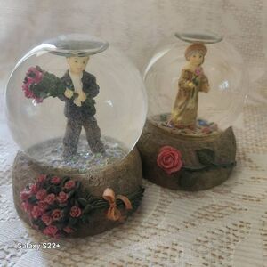 2 small Kim Anderson snow globes featuring a girl and boy with pink roses